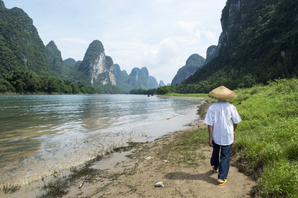Man walking along a river in Asia