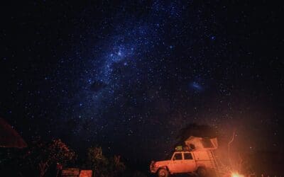 An East African evening under the stars. Supply filled SUV parked by the campfire.