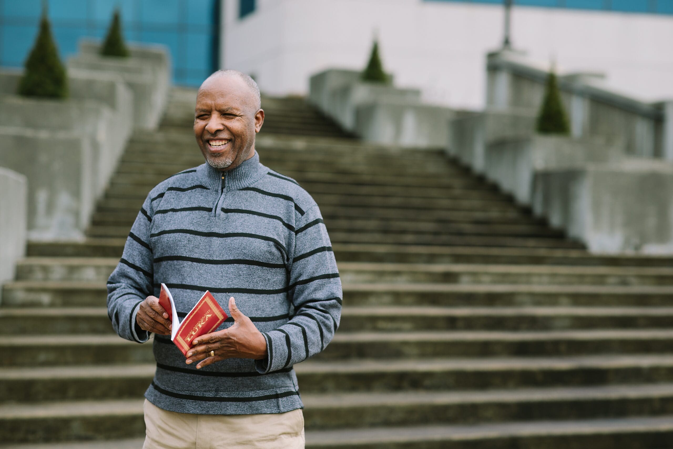 Portrait of Tito holding Kinyamulenge Scripture
