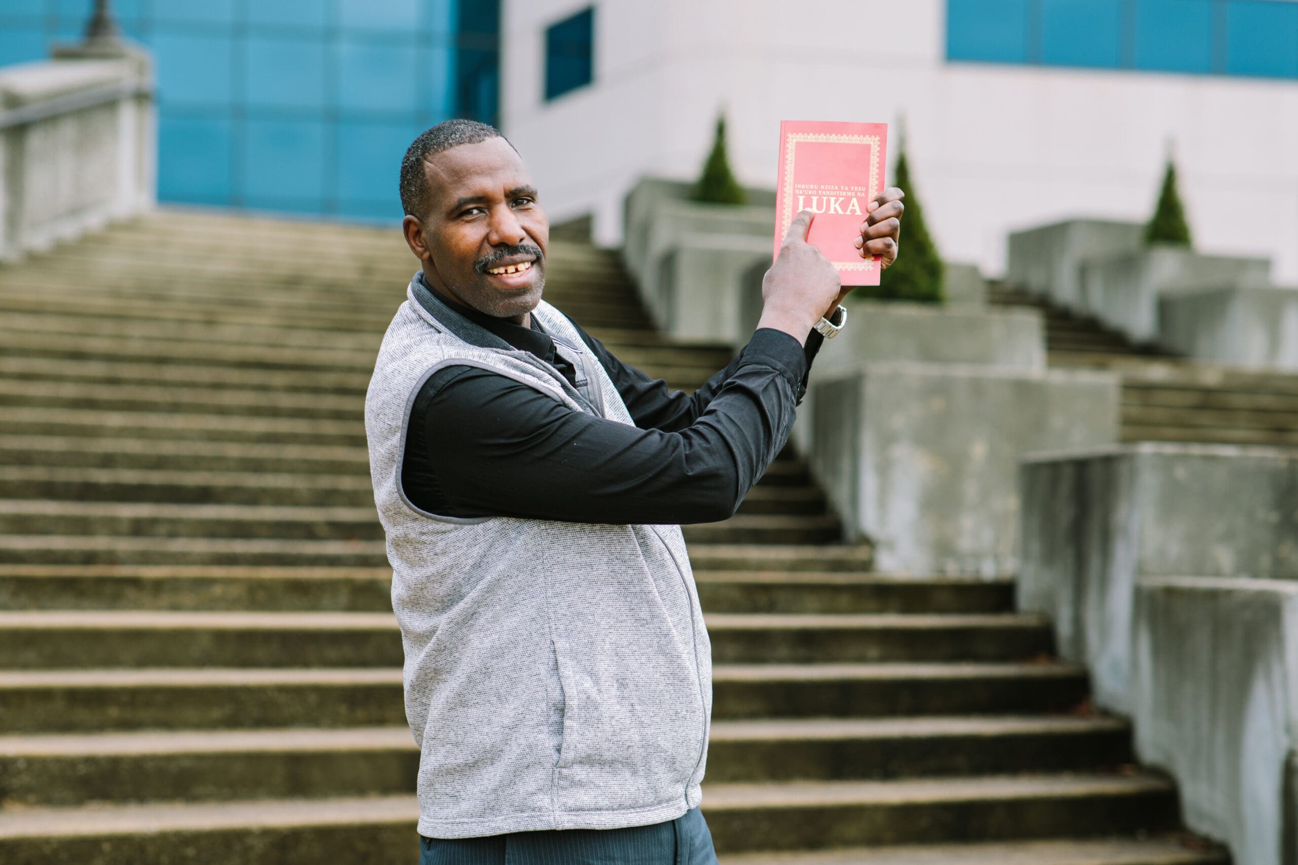 Portrait of Philemon pointing to Kinyamulenge Scripture